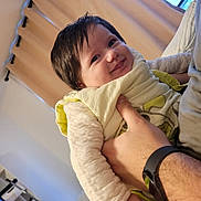 Victoria a rejoint le concours — aidez-le/la à gagner de superbes lots ! baby, child, smile, happy, person, indoor, curtain, hand, clothing, face, portrait, cozy, infant, window, adult_hand, yellow_bib, warm_light, hair, sleeve, soft_texture