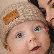 Aymen a rejoint le concours — aidez-le/la à gagner de superbes lots ! baby, infant, adult, blue_eyes, beanie, knit_hat, hand, sweater, cozy, close_up, portrait, cheek_mark, parent, cuddling, indoor, beige_background, eyelashes, gaze, mouth_open, skin