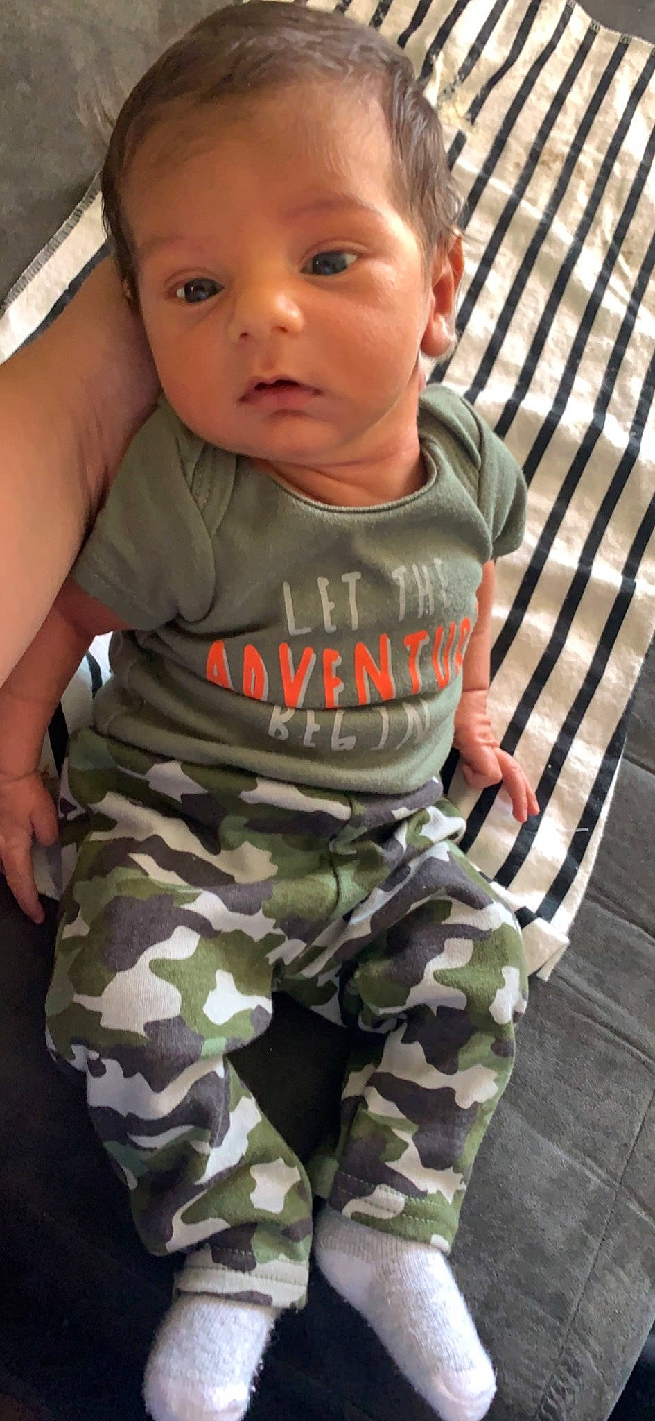 Kayne is registered to the contest to win money with this photo: arm, baby, baby_toddler_clothing, camouflage, cheek, eye, face, finger, gesture, head, joint, military_camouflage, military_uniform, muscle, neck, nose, organ, person, product, skin
