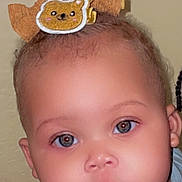 Ruby is registered to the contest to win money with this photo: baby, child, infant, portrait, face, eyes, looking_at_camera, serious_expression, hair_bow, teddy_bear, blue_clothing, indoor, close_up, photograph, smartphone, lock_screen, time_display, selfie, head, safe