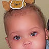 baby, child, infant, portrait, face, eyes, looking_at_camera, serious_expression, hair_bow, teddy_bear, blue_clothing, indoor, close_up, photograph, smartphone, lock_screen, time_display, selfie, head, safe