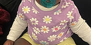 Jalani joined the competition — help win amazing prizes! baby, child, pacifier, purple_shirt, daisy_pattern, yellow_shorts, white_socks, bows, pom_poms, sitting, couch, indoor, cute, infant, portrait, black_background, hand, feet, clothing, face
