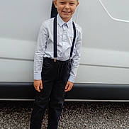 Sheldon participe au concours pour gagner de l'argent avec cette photo : child, boy, smile, standing, suspenders, shirt, black_pants, shoes, vehicle, van, gravel, outdoor, casual, happy, portrait, person, hair, face, clothing, daylight