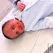 Kelysha participe au concours pour gagner de l'argent avec cette photo : newborn, baby, infant, sleeping, smiling, wrapped, blanket, blue_clothing, crib, mesh, bed, soft, peaceful, face, head, hand, skin, resting, indoors, cute