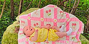 Persephone joined the competition — help win amazing prizes! baby, infant, blanket, yellow_clothing, outdoor, nature, rock, greenery, trees, plants, forest, moss, cute, lying_down, socks, pattern, pink, white, cherry, curious