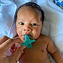 Ajayveon is registered to the contest to win money with this photo: baby, pacifier, hand, tattoo, towel, skin, face, eyes, infant, mouth, blue, closeup, newborn, human, person, lying, soft, cute, expression, natural_light