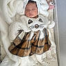 baby, baby_clothing, blanket, cat_costume, crib, crib_bedding, cute, fluffy_outfit, indoors, infant, mesh_rail, newborn, nursery, peaceful, pink_toy, plaid_skirt, plush_toy, portrait, sleeping, white_socks