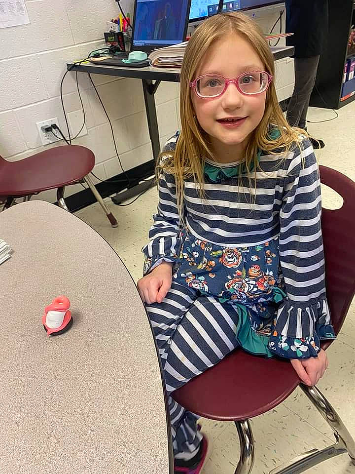 Madison joined the competition — help win amazing prizes! chair, child, computer_keyboard, desk, drum, eyewear, fashion_design, flooring, fun, furniture, glasses, human_leg, joy, knee, pattern, person, room, sitting, t_shirt, table