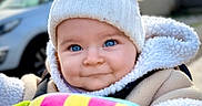 Emy a rejoint le concours — aidez-le/la à gagner de superbes lots ! baby, blue_eyes, child, closeup, cloudy_sky, colorful, cute, expression, face, infant, knit_hat, outdoor, playful, portrait, smile, soft_texture, toy, vehicle, warm_jacket, winter_clothing