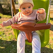 Emy a rejoint le concours — aidez-le/la à gagner de superbes lots ! baby, child, clothing, cute, daytime, feet, grass, green, hat, infant, legs, nature, outdoor, playground, ropes, seat, smiling, sunlight, sweater, swing