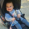baby, stroller, child, smiling, outdoor, sunlight, pacifier, clothing, leggings, checkered, happy, person, seatbelt, toy, blue_eyes, cute, infant, sitting, daylight, nature