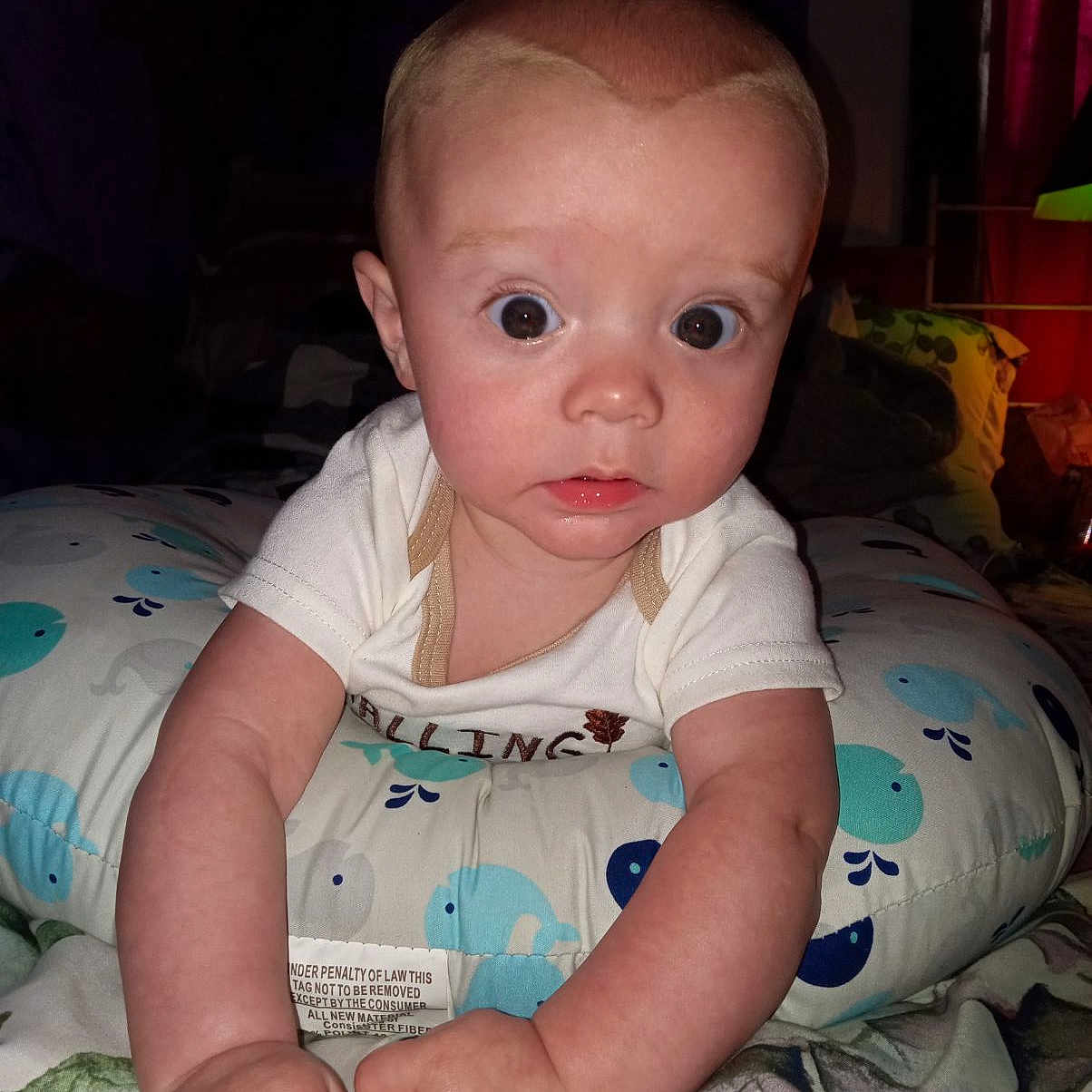 Phoenix is registered to the contest to win money with this photo: baby, bed, bedroom, clothing, couch, crawling, cushion, face, furniture, head, homedecor, indoors, newborn, person, photography, portrait, quilt, room, sitting, t_shirt
