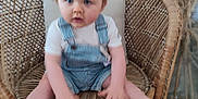 Lilio participe au concours pour gagner de l'argent avec cette photo : toddler, child, wicker_chair, overalls, white_shirt, blue_eyes, indoor, floor, pampas_grass, plant, wooden_floor, furniture, person, baby, seat, portrait, sitting, cute, blurred, homedecor