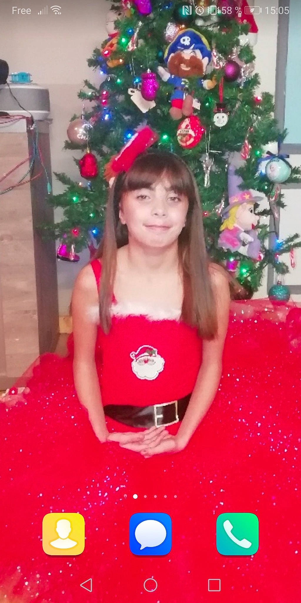 Julie participe au concours pour gagner de l'argent avec cette photo : beauty, christmas_decoration, christmas_ornament, christmas_tree, dress, event, facial_expression, fun, green, happy, holiday_ornament, joy, light, magenta, ornament, person, pink, red, smile, standing