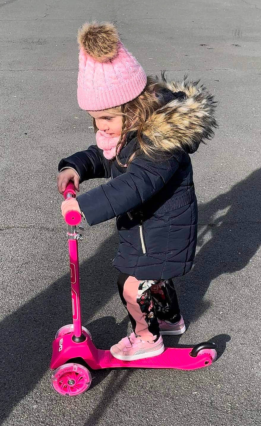 Zoe a rejoint le concours — aidez-le/la à gagner de superbes lots ! asphalt, beanie, cap, child, fun, fur, headwear, human_leg, knee, knit_cap, leisure, magenta, person, photograph, recreation, riding_toy, rolling, shoe, sitting, tire