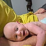baby, infant, smiling, face, arm, yellow_blanket, person, skin, indoor, shelf, decor, room, happy, lying_down, closeup, skin_tone, blanket, baby_face, human, relaxing