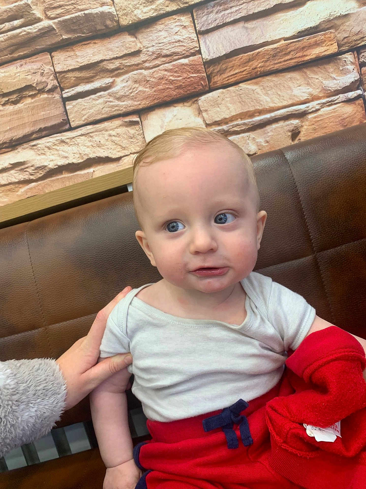 Archi-Rae joined the competition — help win amazing prizes! baby, child, infant, blue_eyes, white_shirt, red_pants, hand, bench, leather, stone_wall, curious, indoor, casual_clothing, portrait, sitting, person, skin, face, young, cute