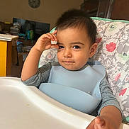 Diego joined the competition — help win amazing prizes! toddler, child, high_chair, bib, smile, face, hand, food_crumbs, indoor, furniture, room, table, clothing, person, hair, expression, seat, baby, portrait, casual