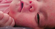 Selina is registered to the contest to win money with this photo: baby, cheeks, close_up, cute, expression, face, hand, head, indoors, infant, lying_down, newborn, person, pink_clothing, portrait, resting, skin, sleepy, soft_texture, young_child