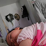 Selina is registered to the contest to win money with this photo: baby, sleeping, pink_clothing, closeup, indoor, wall, decoration, mask, dried_plants, peaceful, child, portrait, person, soft_light, relaxation, head, hair, face, cozy, room