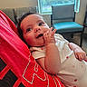 baby, chair, child, chubby_cheeks, curious, cute, expression, eyes, face, furniture, hand, indoor, infant, person, portrait, red_shirt, sitting, skin, white_clothing, window