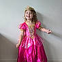 Ellie is registered to the contest to win money with this photo: child, girl, princess_dress, pink_dress, tiara, smiling, curly_hair, indoor, floor, wall, posing, happy, costume, young, person, portrait, celebration, cute, fashion, fun