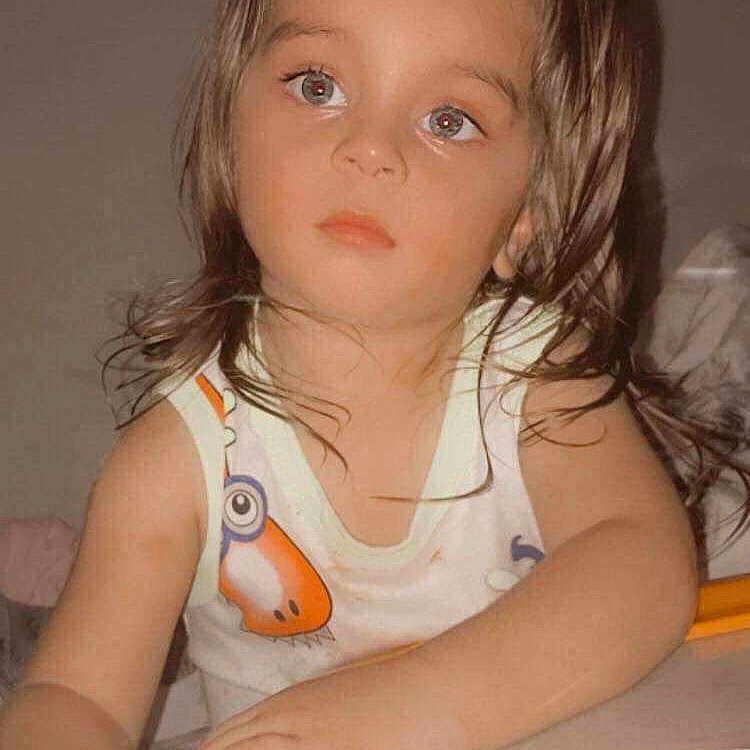 Logan Fournier a rejoint le concours — aidez-le/la à gagner de superbes lots ! background, brown_hair, cartoon_print, child, closeup, cute, expression, eyes, face, hands, holding, indoor, looking_away, person, playtime, skin, sleeveless_top, toddler, toy, young_child