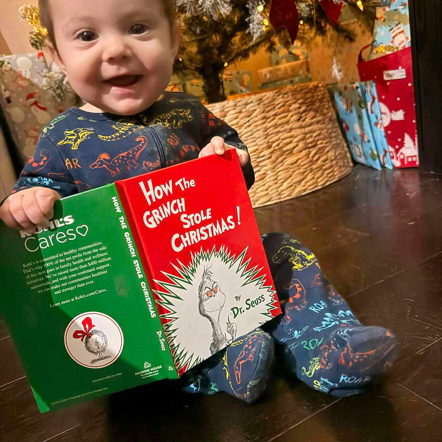 Braxton Jaxx joined the competition — help win amazing prizes! baby, book, child, christmas, christmas_tree, cozy, cute, decorations, dinosaur_pajamas, festive, floor, gift_wrap, happy, holiday, indoor, present, reading, seasonal, smiling, toddler