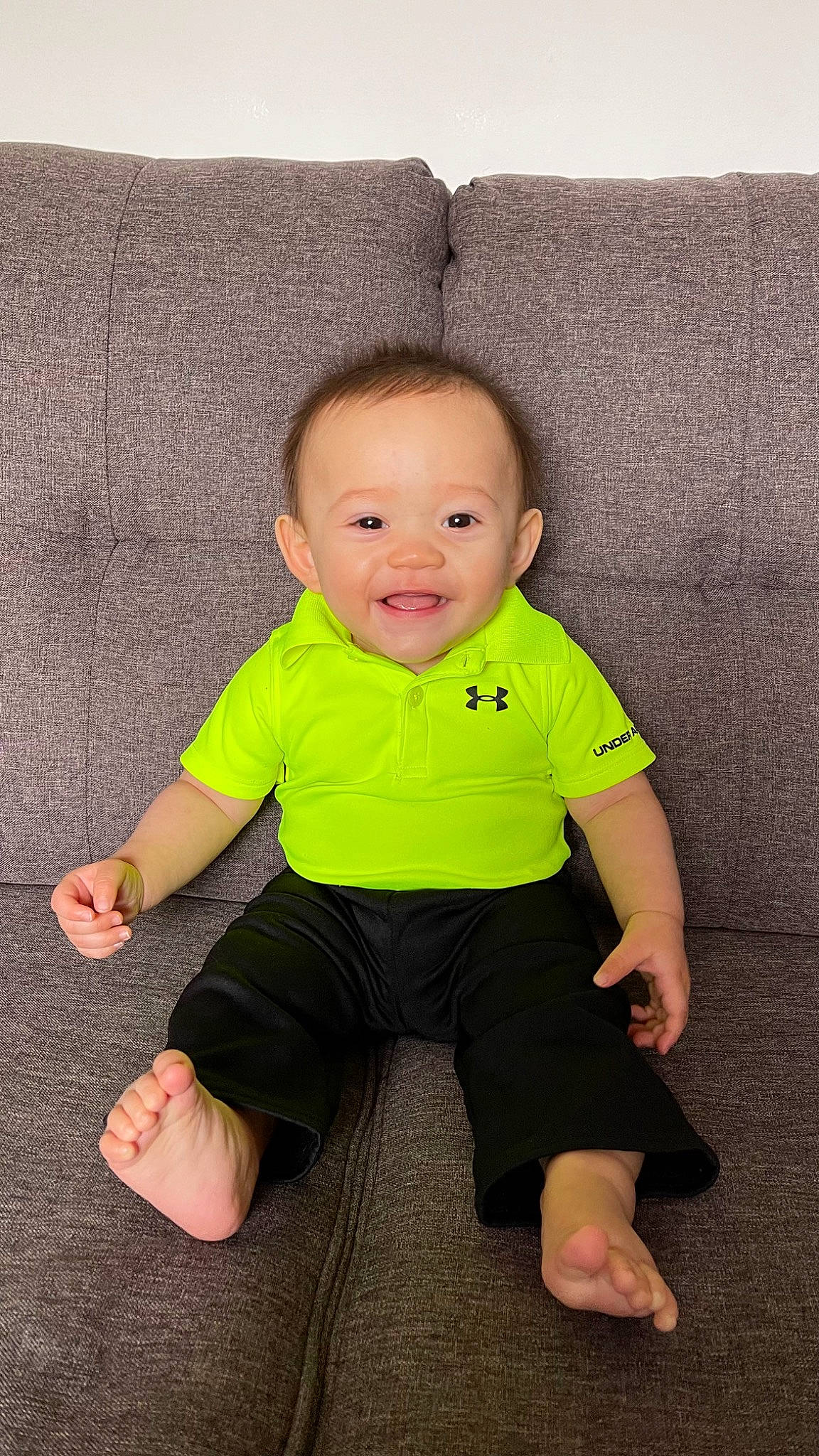 Ronin is registered to the contest to win money with this photo: arm, baby, baby_toddler_clothing, cheek, child, chin, eye, face, floor, flooring, happy, head, human_body, joy, person, sitting, skin, sleeve, smile, t_shirt