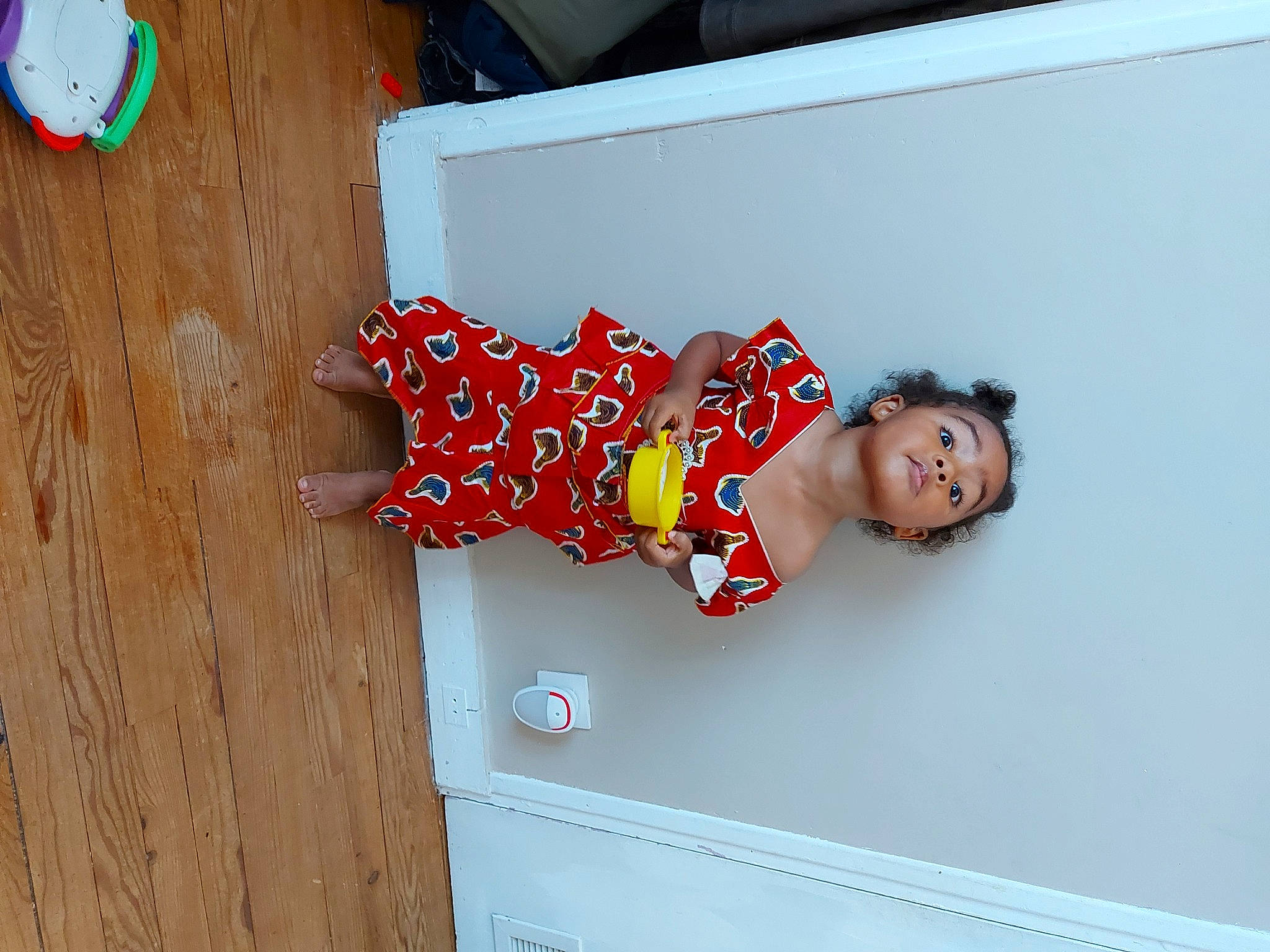 Mélia participe au concours pour gagner de l'argent avec cette photo : carmine, child, elbow, fashion_design, flooring, fun, happy, hardwood, human_leg, pattern, person, room, thigh, toddler, wood, wood_stain, wrist