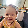baby, smiling, headscarf, necklace, playpen, indoor, child, happy, cute, person, infant, yellow_clothing, reaching, portrait, face, cheerful, bright, daylight, home, baby_girl