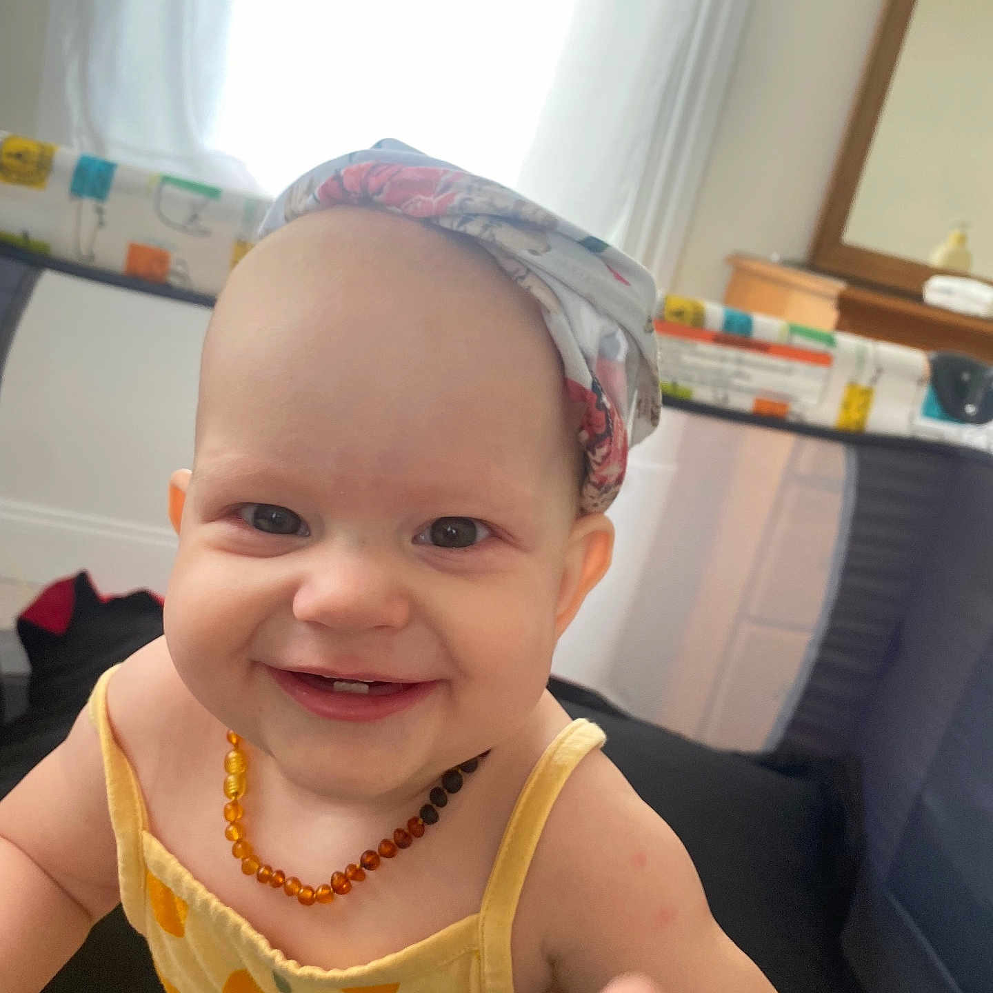 Ottline joined the competition — help win amazing prizes! baby, baby_girl, bright, cheerful, child, cute, daylight, face, happy, headscarf, home, indoor, infant, necklace, person, playpen, portrait, reaching, smiling, yellow_clothing