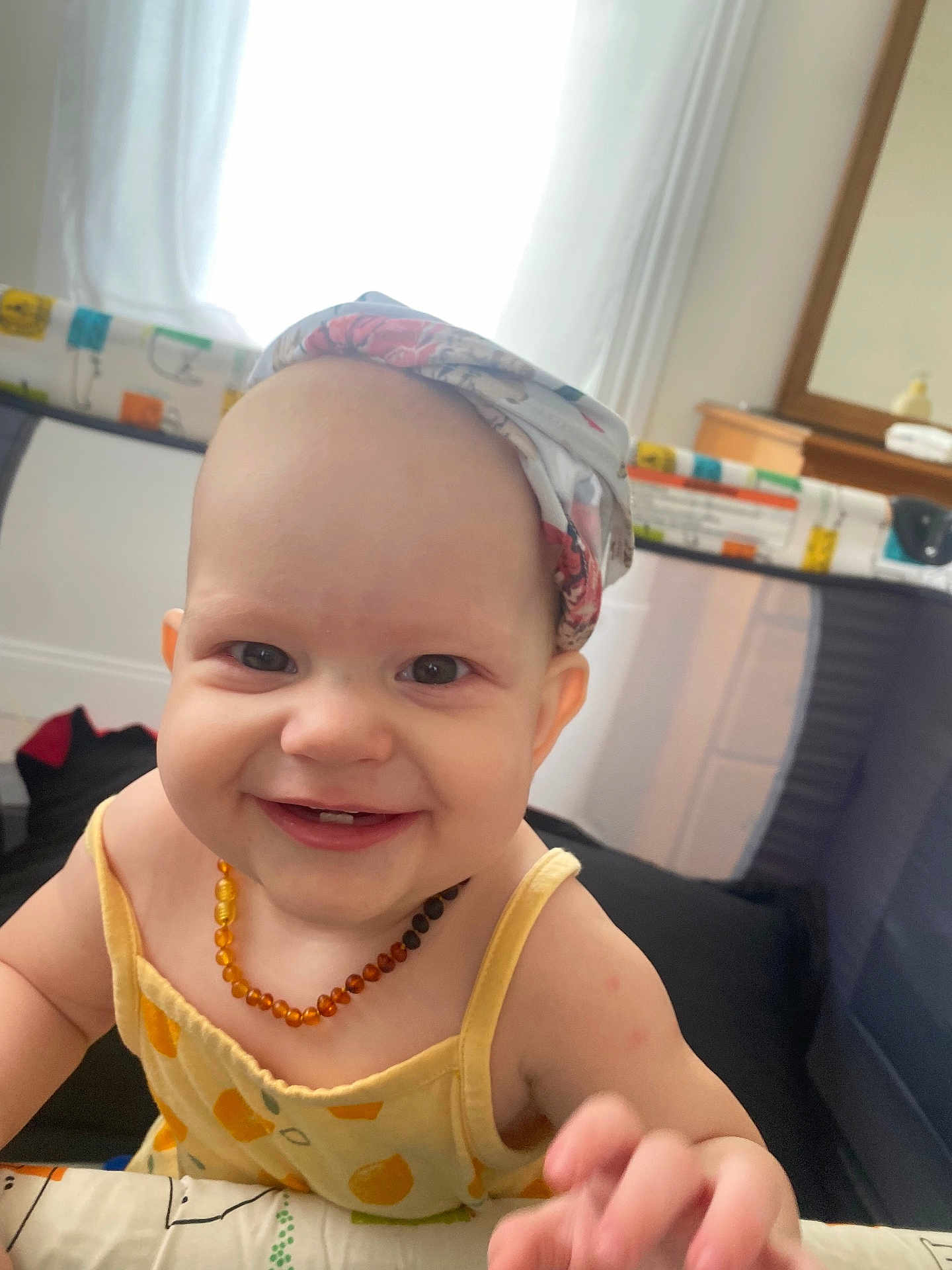 Ottline joined the competition — help win amazing prizes! baby, smiling, headscarf, necklace, playpen, indoor, child, happy, cute, person, infant, yellow_clothing, reaching, portrait, face, cheerful, bright, daylight, home, baby_girl