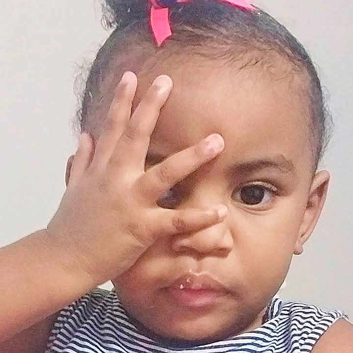 Ammarah is registered to the contest to win money with this photo: blue_beads, child, closeup, curious, cute, expression, eyes, face, gesture, hair_bun, hand, indoor, person, portrait, ribbon, single_person, skin, striped_clothing, toddler, young