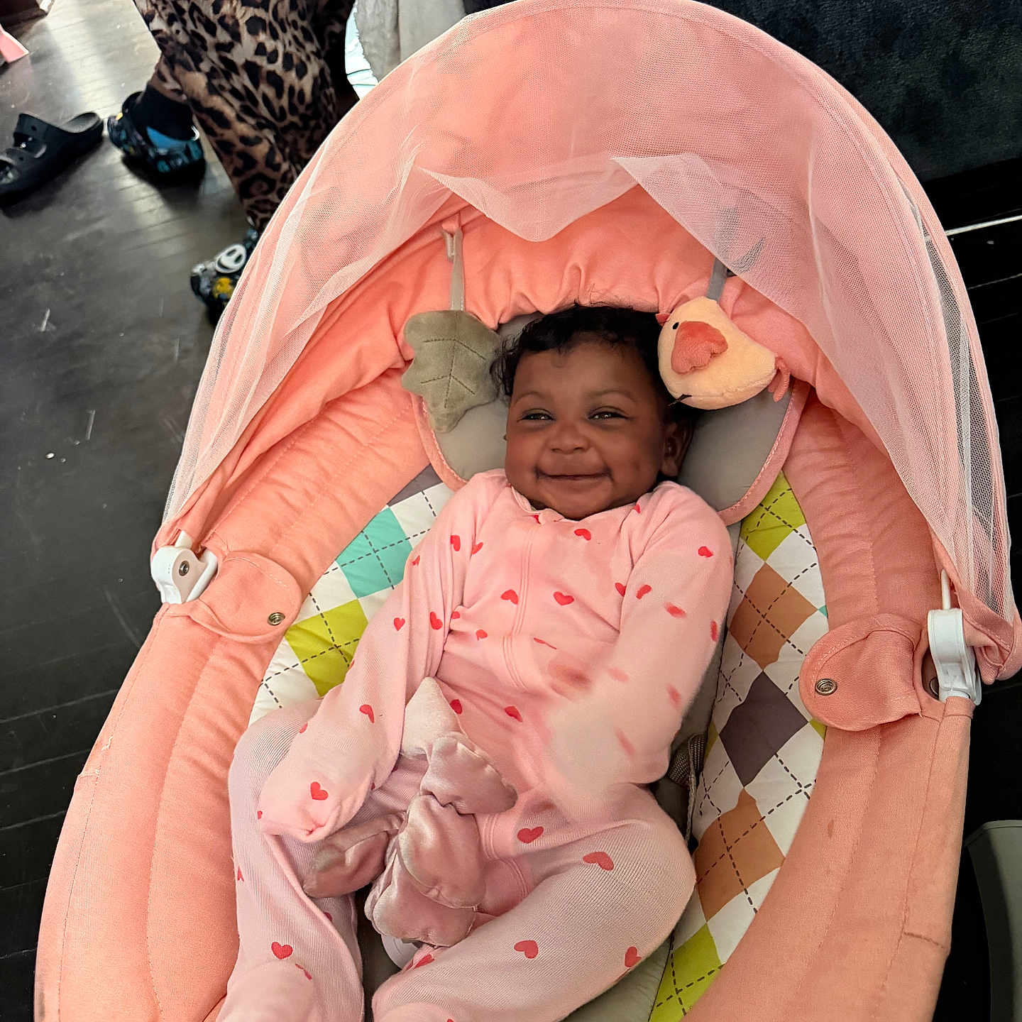 Jreem joined the competition — help win amazing prizes! baby, infant, smile, pink_onesie, baby_seat, mesh_canopy, soft_toys, leopard_print_pants, colorful_shoes, dark_floor, happy, cute, child, portrait, indoor, cushion, person, footwear, patterned_clothing, baby_accessory