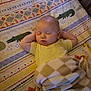 baby, sleeping, blanket, bed, pillow, animal_pattern, toddler, child, cute, indoors, cozy, resting, soft_lighting, yellow_shirt, peaceful, face, hands_behind_head, comfort, nap, plush
