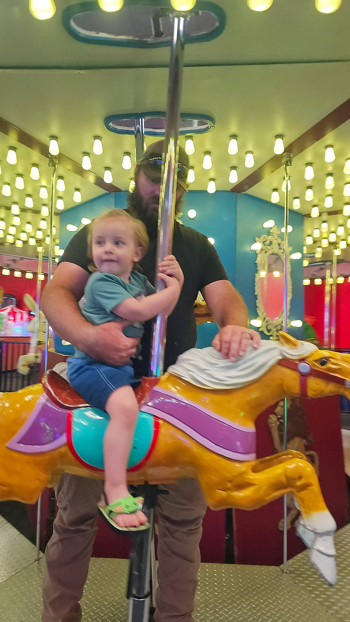Kooper joined the competition — help win amazing prizes! amusement_park, amusement_ride, baby, carousel, child, city, entertainment, event, fun, games, leisure, magenta, nonbuilding_structure, person, public_event, recreation, sandal, shorts, sitting, thigh