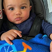 Kolsen is registered to the contest to win money with this photo: baby, blanket, blue, bottle, car_seat, child, clothing, curious, cute, drool, eyes, face, hand, indoors, infant, portrait, seatbelt, sitting, warm, young