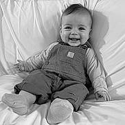 Elladeigh joined the competition — help win amazing prizes! baby, smiling, infant, overalls, socks, bed, blanket, happy, portrait, monochrome, child, cute, clothing, person, face, sitting, cozy, relaxed, indoors, young
