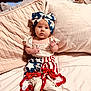 Emerson Rae is registered to the contest to win money with this photo: baby, bed, blanket, blue, bow, child, clothing, cozy, cute, footwear, headband, indoor, infant, pillow, portrait, red, soft, stars, stripes, white