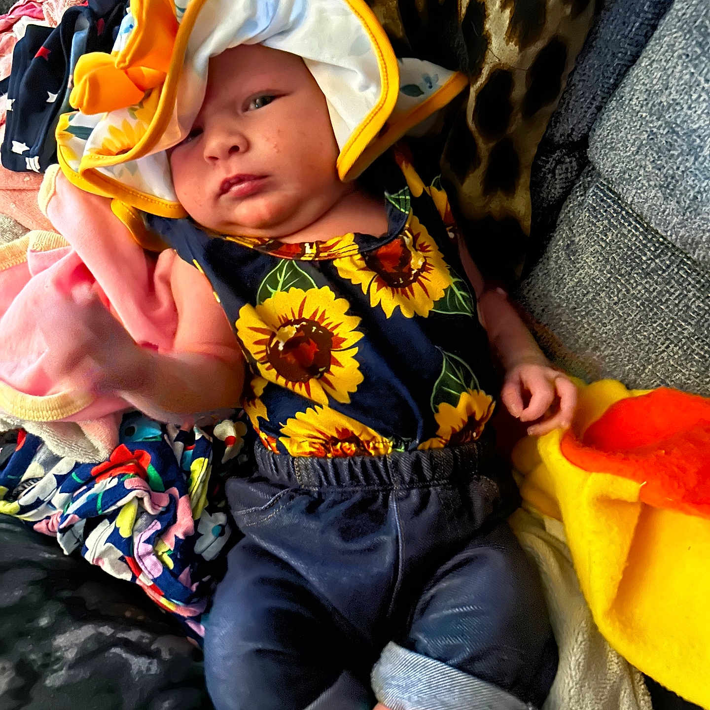Alanna is registered to the contest to win money with this photo: baby, bonnet, cap, clothing, coat, costume, couch, face, flower, furniture, hat, head, hood, pants, person, photography, plant, portrait, shorts, sunhat