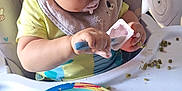 Ethan participe au concours pour gagner de l'argent avec cette photo : bib, cartoon_character, child, cute, eating, face, feeding, food, high_chair, indoor, mealtime, messy, peas, person, pink_food_bits, plate, spoon, table, toddler, yogurt