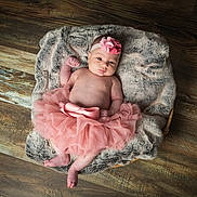 Emmy a rejoint le concours — aidez-le/la à gagner de superbes lots ! baby, infant, girl, pink_tutu, headband, flower, basket, fur_blanket, wooden_floor, barefoot, cute, portrait, child, newborn, soft_texture, indoor, resting, adorable, fashion, lying_down