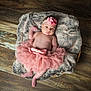 baby, infant, girl, pink_tutu, headband, flower, basket, fur_blanket, wooden_floor, barefoot, cute, portrait, child, newborn, soft_texture, indoor, resting, adorable, fashion, lying_down