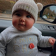Emmy a rejoint le concours — aidez-le/la à gagner de superbes lots ! baby, infant, child, beanie_hat, pompom, chubby_cheeks, onesie, gray_clothing, car_interior, steering_wheel, car_mirror, window, trees, road, winter, portrait, close_up, sitting, hand, cute