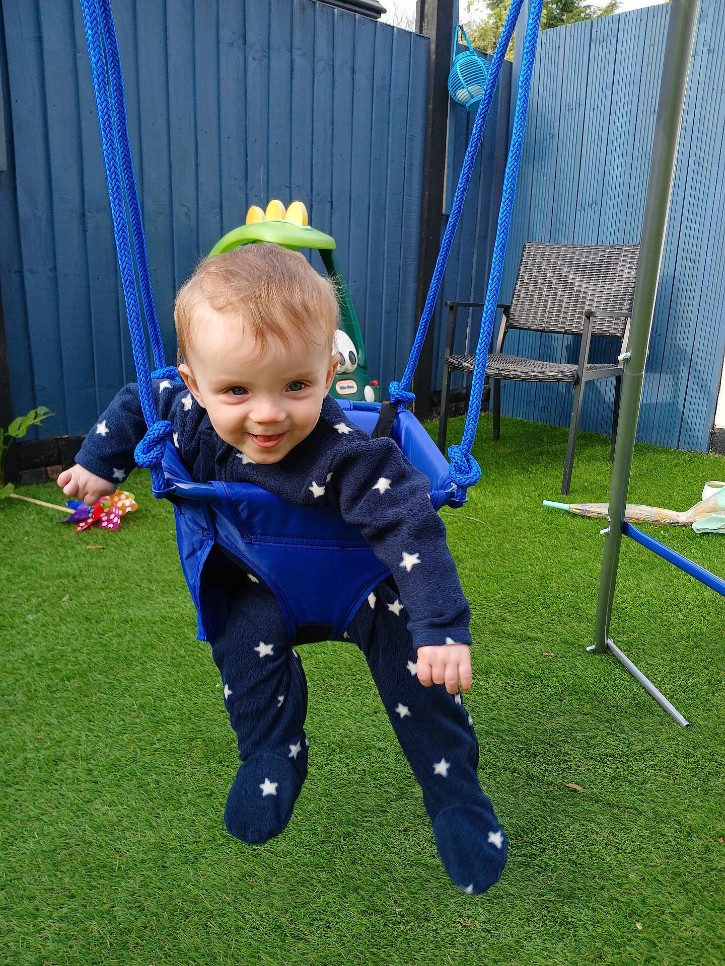 Harrison joined the competition — help win amazing prizes! toddler, child, swing, outdoor, grass, blue_fence, chair, toy, play, happy, smile, star_pattern, onesie, rope, baby, face, person, fun, garden, daylight