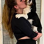 woman, dog, pet, affection, black_clothing, polka_dot_tights, long_hair, indoor, holding, kiss, tricolor_dog, companion, portrait, cute, love, animal, friendship, casual, home, happy