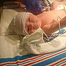 Amiyah joined the competition — help win amazing prizes! newborn, baby, hospital, medical, gloved_hand, stethoscope, blanket, striped, cap, infant, wire, bed, patient, healthcare, person, lying_down, cute, sleepy, care, nursery