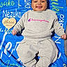 baby, infant, three_months, child, smiling, tongue_out, portrait, lying_down, blanket, blue_blanket, gray_outfit, sweatshirt, pants, champion_logo, heart_sign, milestone_photo, indoor, happy, face, photography