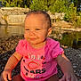 baby, clothing, face, head, nature, outdoors, pebble, person, photography, plant, pond, portrait, rock, sitting, soil, summer, t_shirt, tree, vegetation, water
